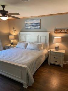 ゲインズビルにあるCozy 4br Lake Lanier GA Waterfront- Great Locationのベッドルーム1室(白いベッド1台、ナイトスタンド2つ、ランプ2つ付)