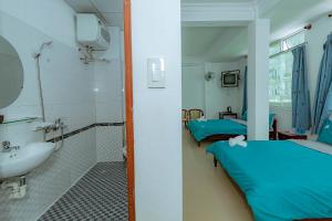 a hospital room with two beds and a sink at Wealth Pearl Dalat Hotel in Da Lat