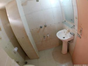 a small bathroom with a sink and a shower at Hotel Surma Residential in Dhaka