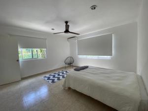 1 dormitorio con 1 cama y ventilador de techo en The Hostal Inn, en Playa del Carmen