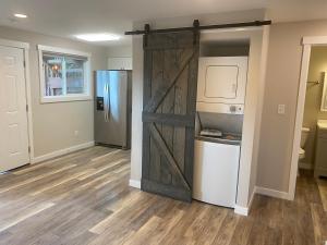 una puerta corredera de granero en una cocina con nevera en Valley Escape in Quiet Area Neighborhood en Spokane Valley