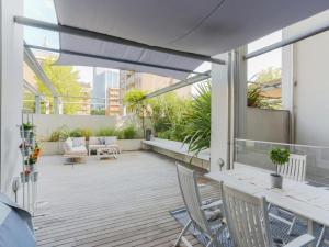 ミラノにあるThe Best Rent - Apartment with terrace and Jacuzziの屋外パティオ(椅子、パラソル付)