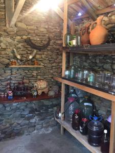 a room with wooden shelves in a stone wall at Mera Hostel in P'arts'khanaqanevi