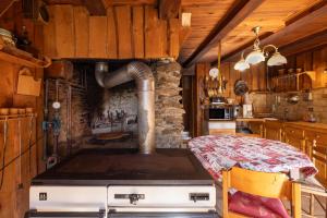 a kitchen with a stove and a table in it at Chalet D'alpage Authentique in Queige