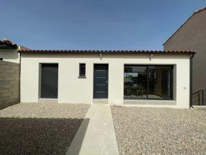 Casa blanca con puertas negras y patio en Tierra Del Viento - Villa Proche de la Mer, en Peyriac-de-Mer