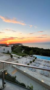 a view of a pool and the ocean at sunset at Duplex Seaview Condo in Durrës