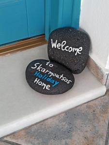 Un par de rocas sentadas en un banco. en Skarmoutsos Holiday Home, en Vourvoúlos