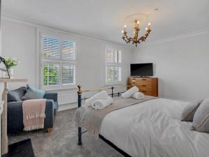 a bedroom with a bed and a chair and a chandelier at Pass the Keys Luxury Townhouse In The City in Canterbury