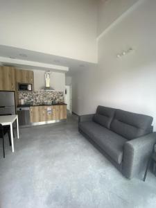 a living room with a couch and a kitchen at Apartamentos Santamira Street in Santillana del Mar