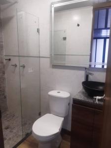 y baño con aseo y ducha acristalada. en Nativo 106 Smart Living - Modern and cozy, en Bogotá