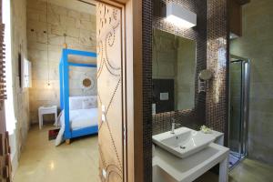 a bathroom with a sink and a mirror at Don Agostino Relais Masseria in Martano