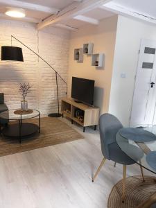 a living room with a television and a table and chairs at Przytulny apartament SUDECKI KLIMAT by SpaceApart in Szklarska Poręba