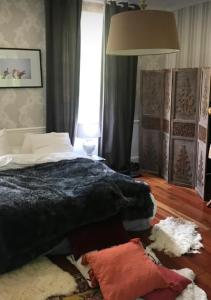 1 dormitorio con 1 cama con manta negra en Le château de cartes des Massés, en Villeneuve-la-Guyard
