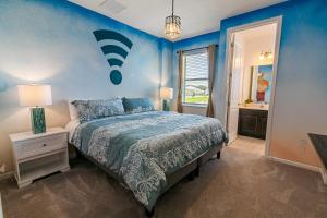 基西米的住宿－Luxury 12 bedrooms pool house 10 Min to Disney，一间卧室设有一张床和蓝色的墙壁