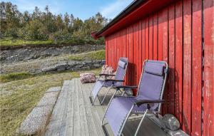 two chairs sitting on a deck next to a red building at Amazing Home In Reinli With 3 Bedrooms in Reinli