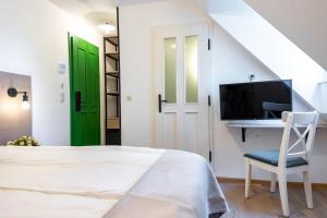 um quarto com uma cama, uma secretária e uma porta verde em Czakó Bed&Breakfast em Budapeste