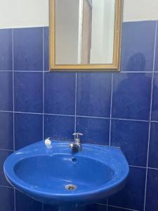RéunionにあるModern guesthouseのバスルーム(鏡付きの青い洗面台付)