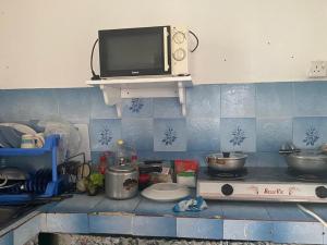 a kitchen counter with a tv on top of a stove at Modern guesthouse in Réunion