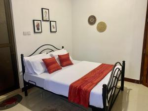 a bedroom with a bed with orange and white pillows at GOLDEN TASTE REST HOUSE in Dar es Salaam