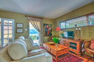 a living room with a couch and a table at Red Door Cottage in Wilderness