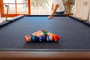 a man playing a game of pool on a pool table at Delfines de Chicama Hotel in Puerto Chicama
