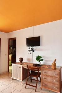 un bureau avec un bureau et une télévision murale dans l'établissement Logement entier au soleil couchant, à Deshaies