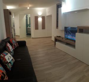 Una sala de estar con un sofá y un televisor de pantalla plana. en Luna&Siria, en Salerno