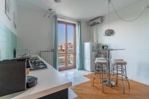 a kitchen with a counter and stools in it at CasaTella - Monolocale - letto matrimoniale - angolo cottura - bagno e balcone in Vidigulfo