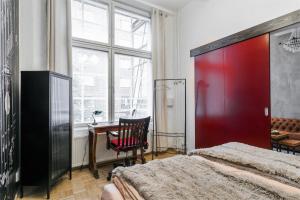 Schlafzimmer mit einem Bett, einem Schreibtisch und einem Fenster in der Unterkunft Loft in an old factory in Turku