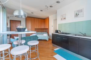 a kitchen with a counter and stools in a room at CasaTella - Monolocale - letto matrimoniale - angolo cottura - bagno e balcone in Vidigulfo