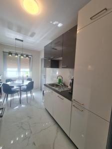 une cuisine blanche avec une table et une salle à manger dans l'établissement Mias luxury spa apartment, à Rijeka
