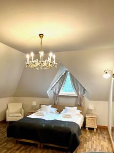 - une chambre avec un grand lit et un lustre dans l'établissement Na Skarpie, à Sasino