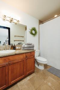 a bathroom with a sink and a toilet and a mirror at The Bamboo House in Kailua-Kona