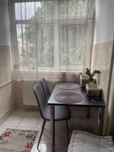 a table and chairs in a room with a window at Ultracentral Studio in Craiova