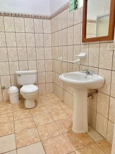 a bathroom with a toilet and a sink at Hotel Firenze in Tarapoto