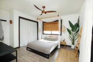1 dormitorio con 1 cama y ventilador de techo en The Bamboo House, en Kailua-Kona