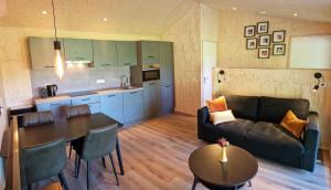 a living room with a couch and a table at Chalet de Scherpenweide in Leur