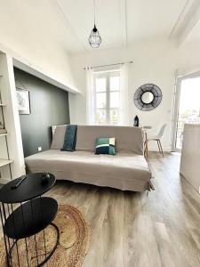 una sala de estar con un sofá y una mesa en L'Agate bleue - Bourg-de-Péage, en Bourg-de-Péage