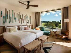 a bedroom with a large bed and a large window at Kimpton Aysla Mallorca by IHG in Santa Ponsa