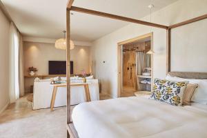 a bedroom with a white bed and a desk at La Bastide Saint Georges & Spa in Forcalquier