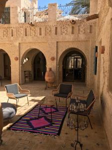 eine Terrasse mit Stühlen und Tischen in einem Gebäude in der Unterkunft Dar Aron Tozeur in Tozeur
