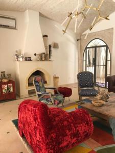 a living room with a red couch and a fireplace at Dar Aron Tozeur in Tozeur