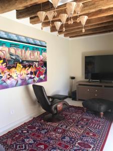 ein Wohnzimmer mit einem Stuhl und einem großen Teppich in der Unterkunft Dar Aron Tozeur in Tozeur