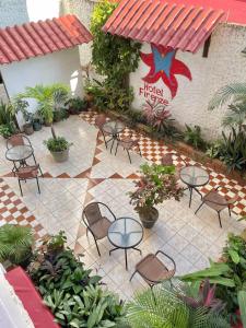 eine Terrasse mit Tischen und Stühlen im Innenhof in der Unterkunft Hotel Firenze in Tarapoto