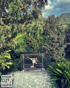 烏代浦的住宿－The Riverside Estate - 2Bedroom Private Pool Villa in Udaipur，一个人站在楼梯上的栏杆上