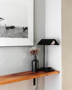 a black lamp and a vase on a wooden shelf at MooiBaai in Hout Bay