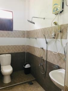 a bathroom with a shower and a toilet and a sink at Elephant Side Bungalow in Udawalawe