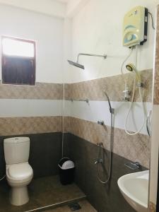 a bathroom with a shower and a toilet and a sink at Elephant Side Bungalow in Udawalawe