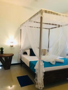 1 dormitorio con 1 cama con dosel en Elephant Side Bungalow en Udawalawe