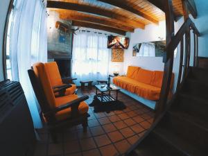 a living room with an orange couch and a table at Los Cerezos in San Martín de los Andes